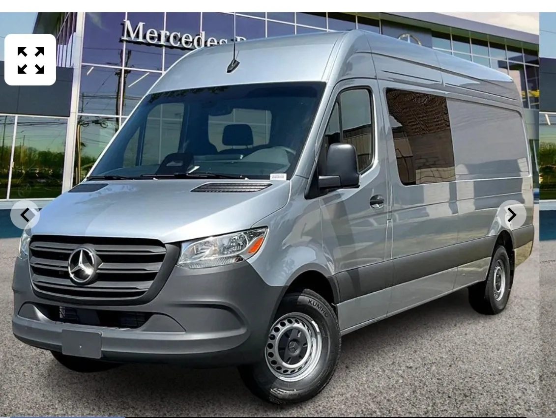 Silver Mercedes-Benz van parked outside building.