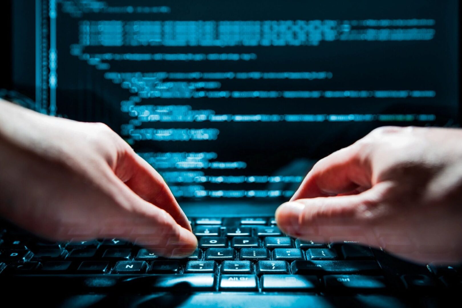 A pair of hands working on the keyboard of laptop