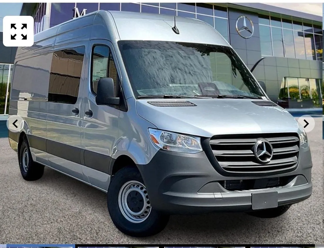 Silver Mercedes-Benz van in front of dealership.