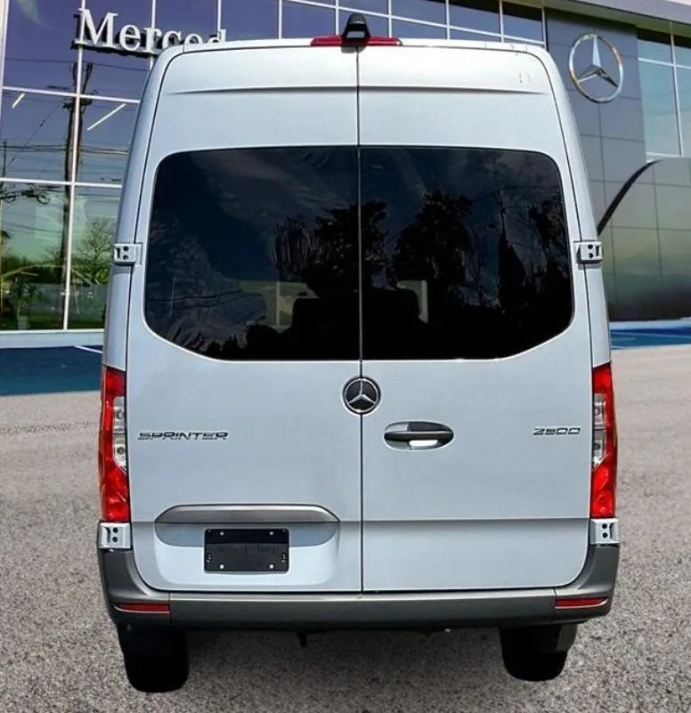 White Mercedes van parked outside dealership.