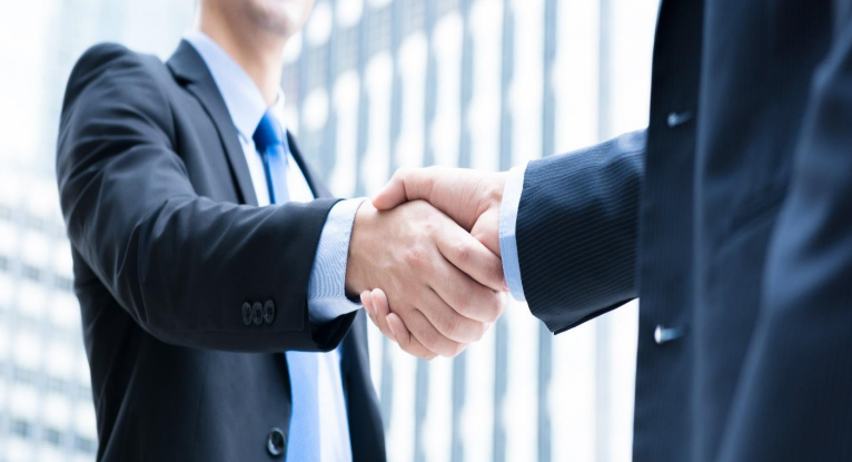 Two businessmen shaking hands in a deal.