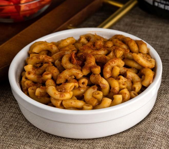 Bowl of elbow macaroni with chili seasoning.