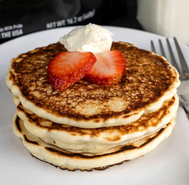 Buttery pancakes with strawberries and cream.