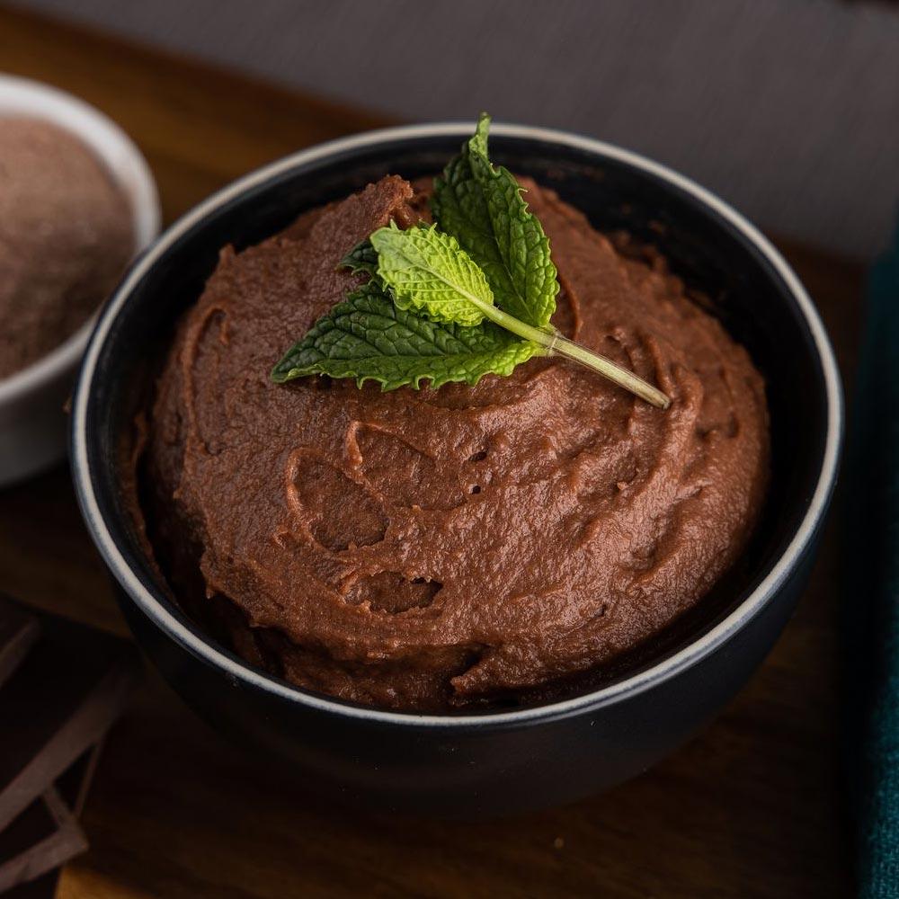 Chocolate mousse with mint garnish in bowl.