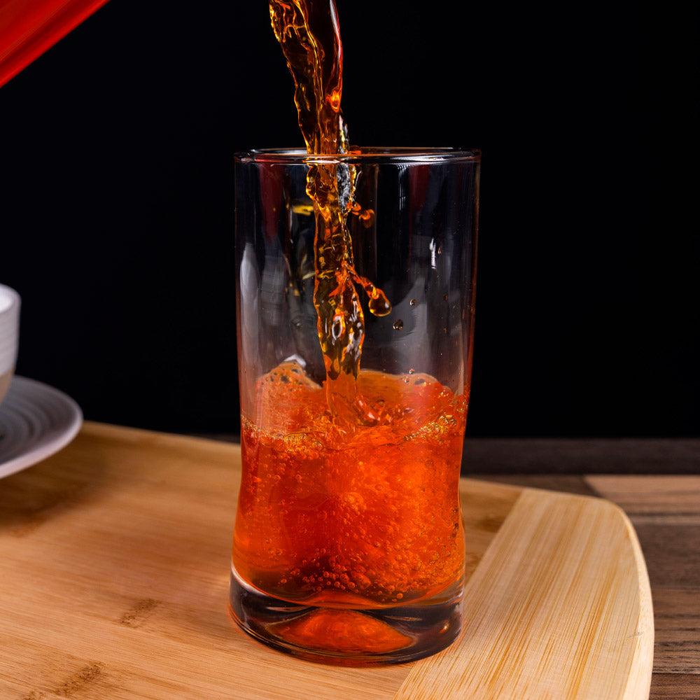 Orange liquid being poured into a glass.