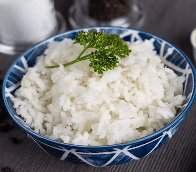 White rice in a blue bowl with parsley.