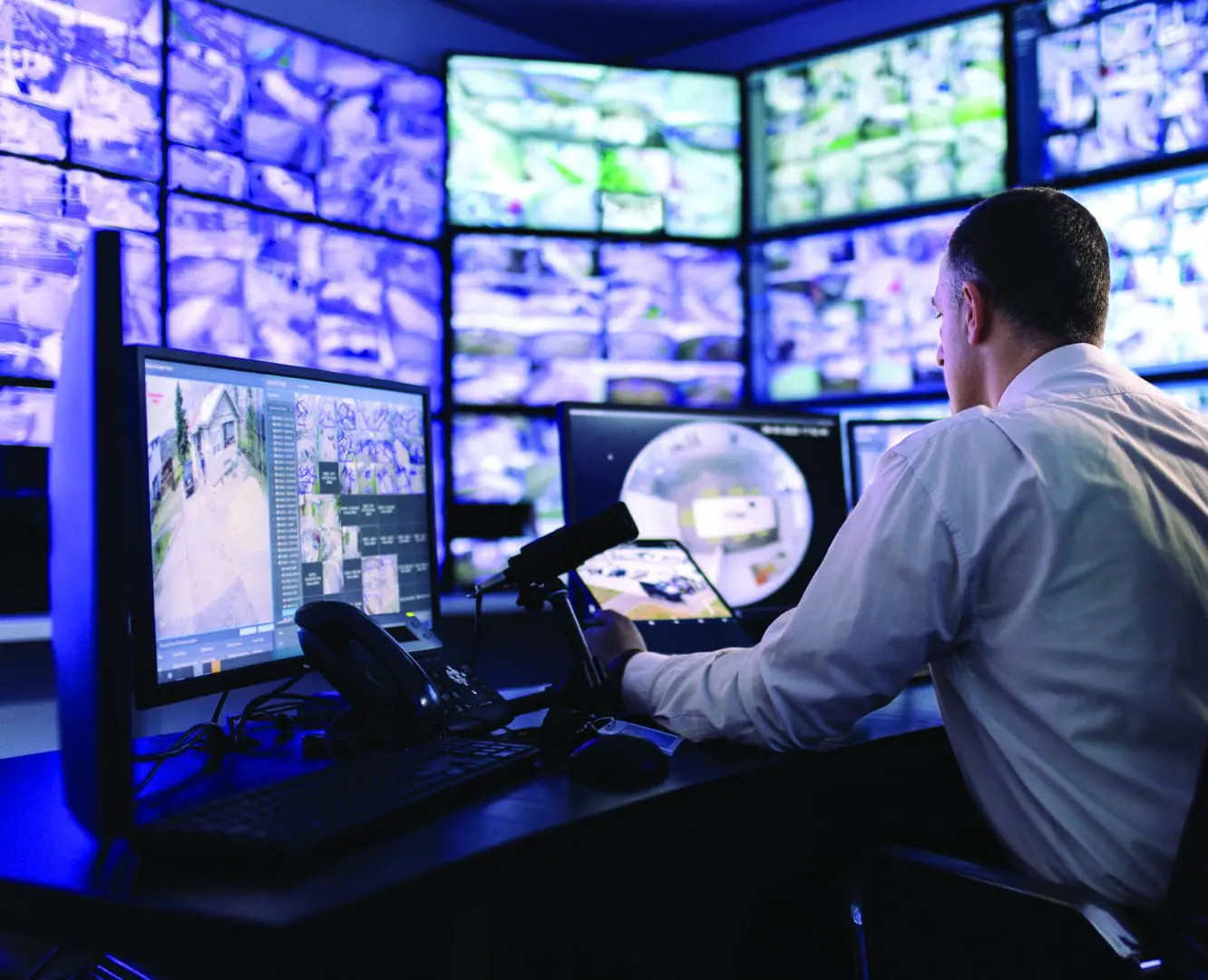 Security guard monitoring multiple screens.