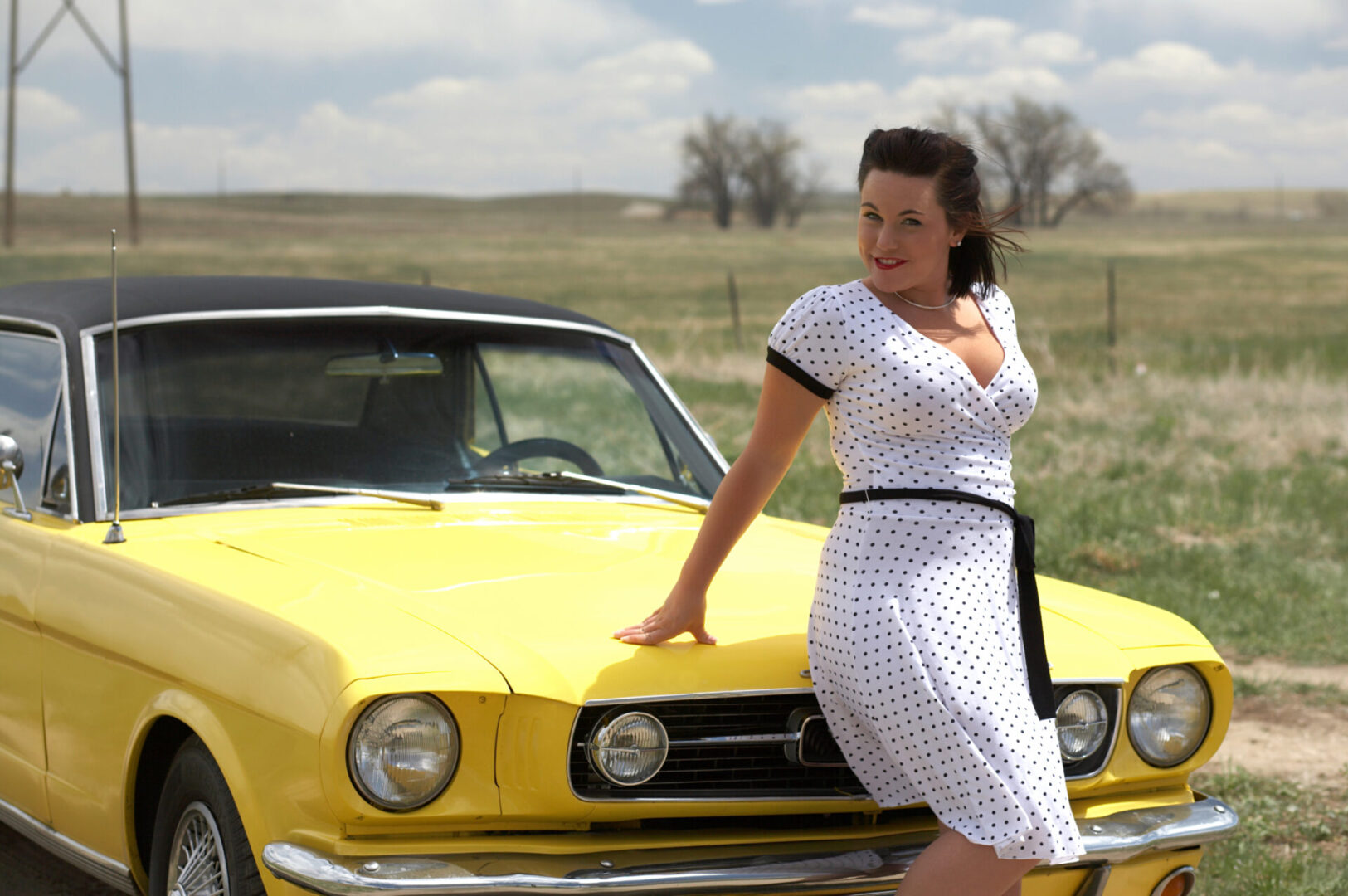 Young pinup model with forty year old classic car