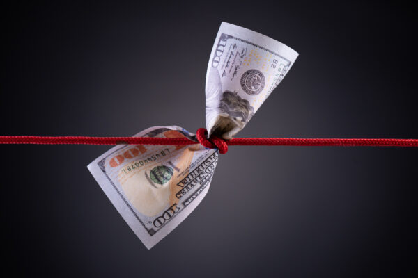 A red string with a dollar bill tied to it.