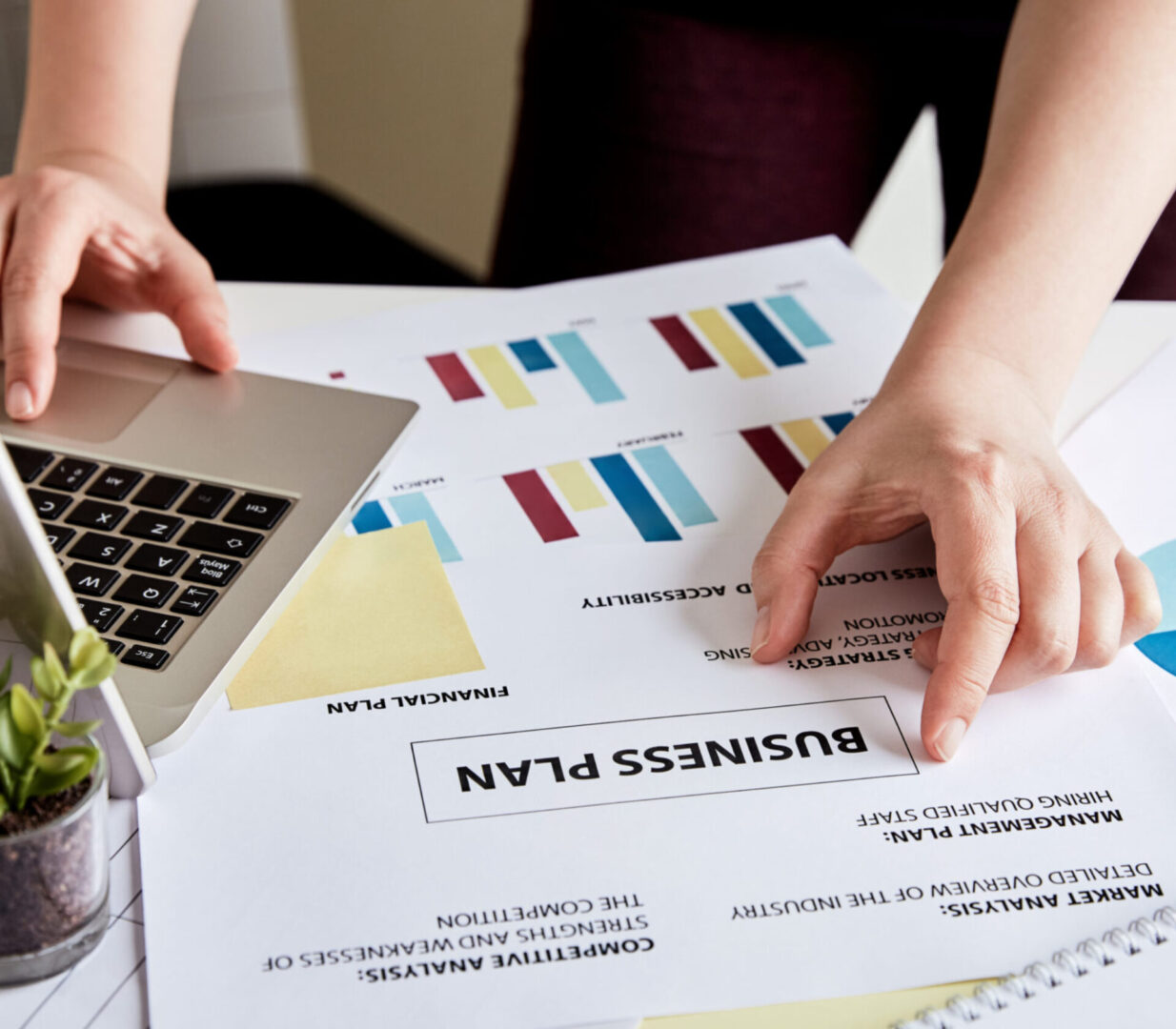 Hands working on business plan documents.