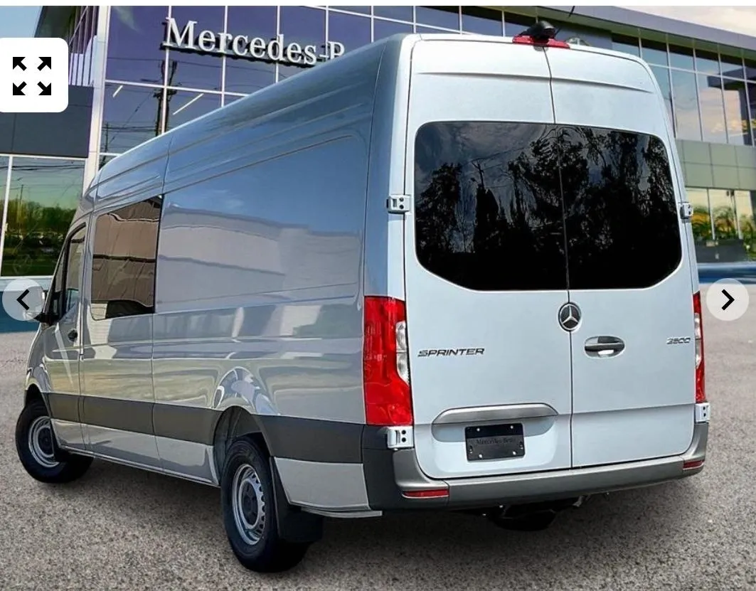 Silver Mercedes van parked outside dealership.